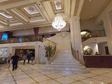 Staircase from lobby leading to a bookstore and another bar upstairs