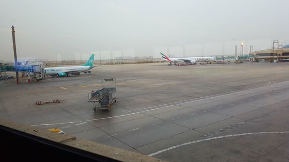 A view of the tarmac. An Emirates 777 heading to Dubai, with 5 daily services from KHI, Emirates has the biggest influence in KHI among international carriers. Towards the domestic side another Serene jet preparing for departure.