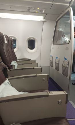 Front row , hardly comfortable with the fixed armrest and note the glazed panel in front of 1AC.