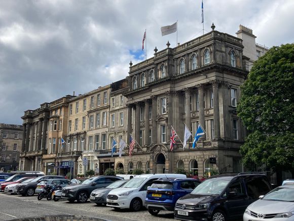 The hotel consists of multiple buildings: the right pillared section contains the main lobby and reception