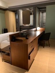I quite like the idea of the work desk being behind the bed. Frees up space in front of the TV or along the window.