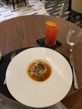 Hamachi crudo as the first course; a mocktail in the background 