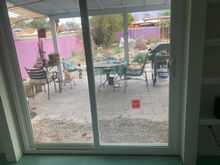 Here are some not very good photos of our completed project( well, still needs painting and curtain rod.)The slider  has sets of shelving on both sides . I can’t find the before picture, but it was a  regular 4” wide window.
Previously the only door to the back of the house was in my wife’s studio, which was problematic.
The patio is in disarray but you can get the idea. 
We are waiting for the drywall mud to dry, and then paint.