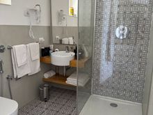 Bathroom of superior room.  No bidet but there is a fixture next to toilet with a hose that substitutes.  But how to use without getting floor soaked?   Use over toilet?