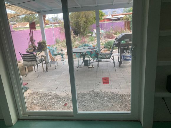 Here are some not very good photos of our completed project( well, still needs painting and curtain rod.)The slider  has sets of shelving on both sides . I can’t find the before picture, but it was a  regular 4” wide window.
Previously the only door to the back of the house was in my wife’s studio, which was problematic.
The patio is in disarray but you can get the idea. 
We are waiting for the drywall mud to dry, and then paint.