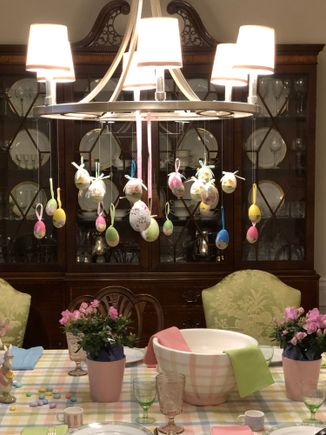 Paper mache eggs suspended from the chandelier which, because two leaves are in, is no longer centered on the table! 