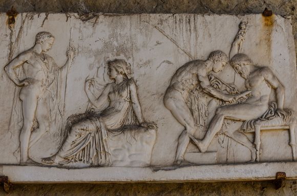 I'm a History major who has worked on one archaeological dig. Here on the right, brave Achilles renders aid to Telephus, the injured son of Hercules. Achilles does so by scraping magic rust off his own spearhead, to apply to the gut wound. 
The scene on the left shows fair Achilles consulting with the Delphic Oracle in Greece.
