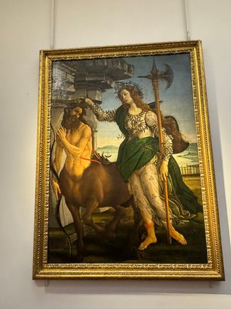 Pallas and the Centaur by Botticelli. It is believed that the feminine figure is Pallas Athena (Minverva), goddess of knowledge, or Camilla, virgin and warrior. She is dragging the centaur by the hair. 