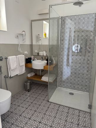 Bathroom of superior room.  No bidet but there is a fixture next to toilet with a hose that substitutes.  But how to use without getting floor soaked?   Use over toilet?