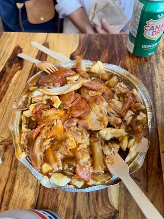 An enormous serving of Ma Poule Mouillée’s “Poutine with São Jorge cheese, Grilled Chicken & Chouriço .”