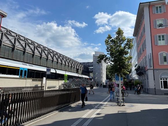 Hotel is the pink building, bicycle parking and train station adjacent. 