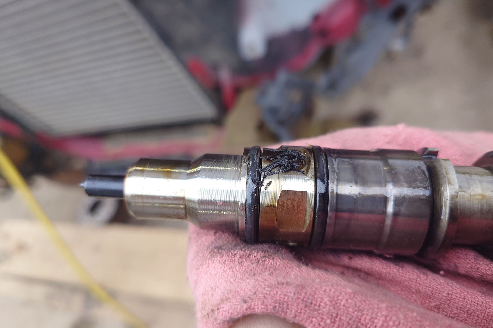 Neighboring injector to loose injector. Fuel ports clogged with o-ring shed from loose injector.