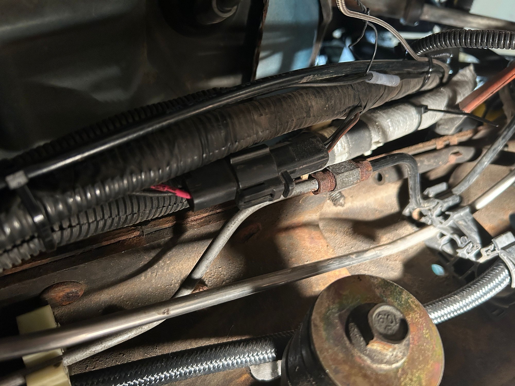 Drivers side just above the sway bar link. 