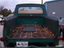 Rear with 55 f100 tailgate on what I can only guess is a piece of plywood used as the bed liner.