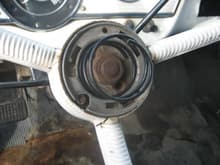 put the horn contact brush with plastic insulator back in it hole.  Alppy pressure to the insulator to seat, being careful not to damage the brush.  Place the big spring back in the cneter of the steering wheel