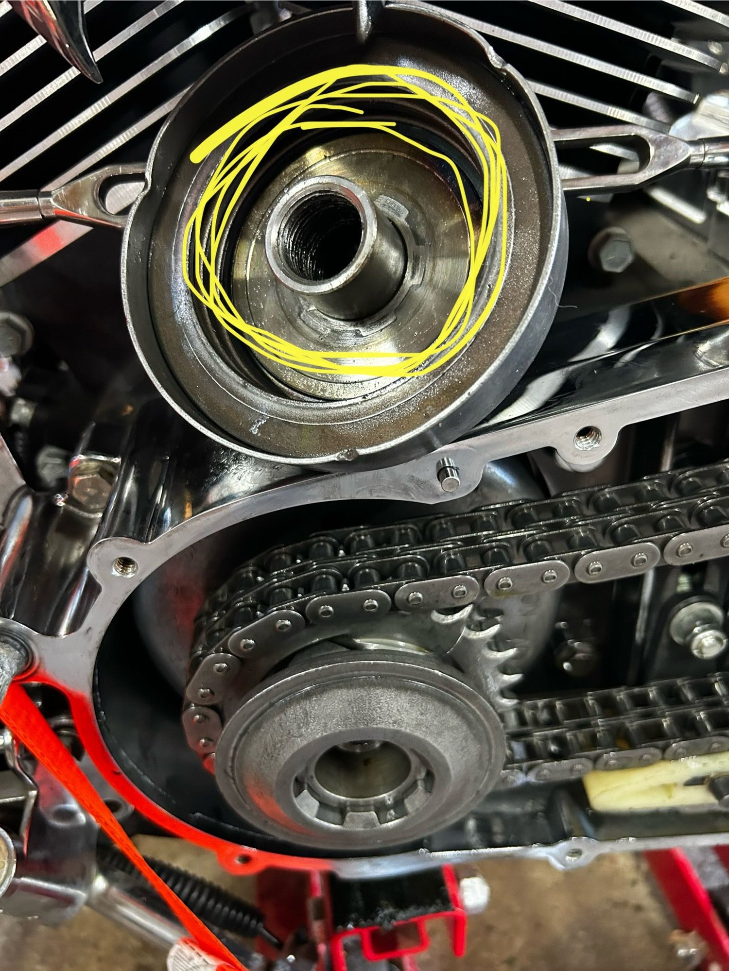 View of bolt from inside compensator cover with crankshaft shoulder below. Bolt threads are inside. 