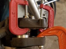 I used some c-clamps to hold 3 pistons in then pumped the brake lever until the fourth was about 1/2" out. Any farther and you risk them popping out completely which is a whole new can of worms.