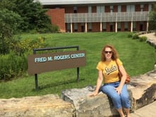 The wife in front of the sign for the Fred Rodgers center.