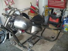 Trike 001 
I just started hanging my first few parts on the bike after getting the frame home . I put a set of 6 gallon fat bobs with bolt it AC bungs, Yaffee roadster oil tank and a corbin solo seat from a FLHR with billet shocks. I picked up the fat bobs for 59.00 the Yaffee oil tank for 100 and the corbin for a 150.00 and the legend forward contrls for 225. Oh ya this was even better the new wild 1 bars for 62 bucks brand new. I not going to bother tell you about the shocks for the seat because I am nuking them for a air ride seat suspension. I know about now you saying what happen to the budget. Well I pick that up for 300 for the same thing JP cycles sells for 1200 or more. The guy that makes the one that JP sells is a crook. That unit is a little more refined but is a not need for anyone that is building a custom chop.