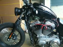 Coil/ignition relocated, drag bars, custom headlight, black heat shields and A/C