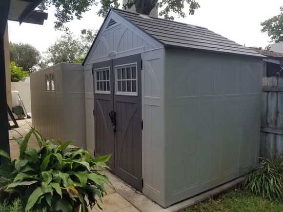 The existing shed in its relocated position and the walls of the new shed standing up.