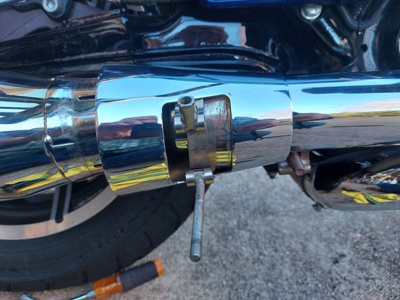 To slide the cone out of the way, you have to be able to lift the chrome shield high enough to slide the pipe clamp,  seen just to the right of the cone on the bottom of the cover, forward out of the way. 