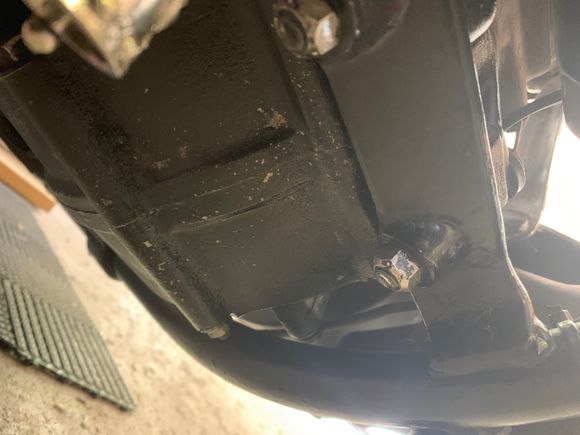 So right underneath the front of bike two screws it’s the one on the right . This is right under the oil filter that doesn’t seem to be leaking at all