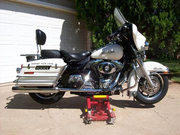 A few changes already. A little trim here and there (front fender, tanks, windshield, rear boards), a back seat from Mustang and HD quick detach tall sissy bar and pad. Also new HD nostalgic grips and fairing mount mirrors. I'm playing around with the POLICE logos but I'll probably do something else with them.