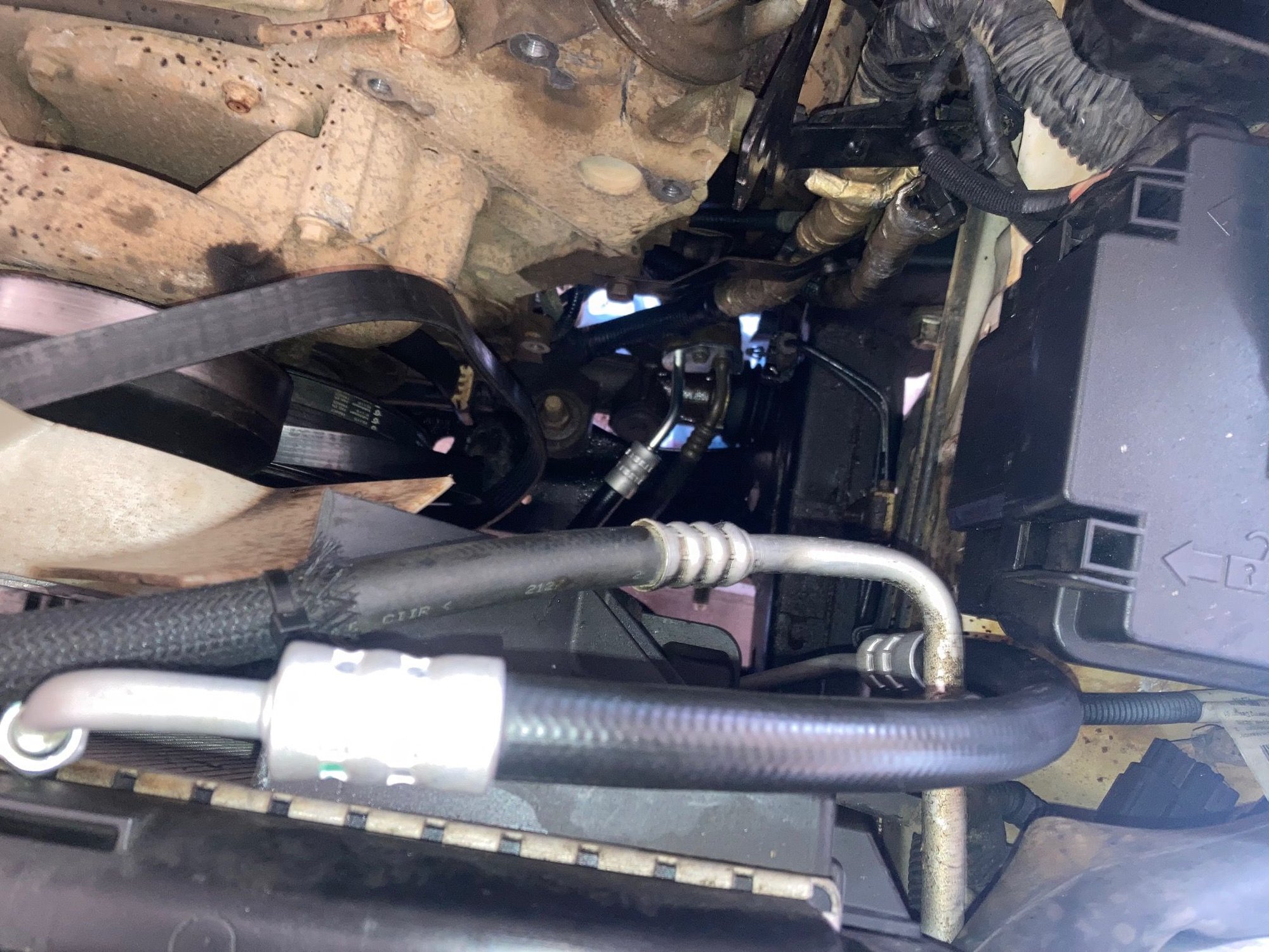 New hose installation; not a perfect fit, but you can see that it can now install on the top of the power steering pump.  