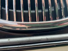 Bottom tooth of the grille above the plate