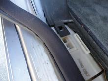 How left front kick panel fits into cable tray with door seal pulled loose for access