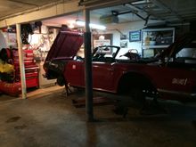 Old Triumph TR6 in garage with tools, parts