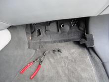 The two retainers for the insulation located at the two corners of the insulation.  Insulation just slid out to the rear after the retainers were removed