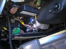 just to the left of the steering column