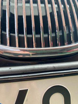 Bottom tooth of the grille above the plate