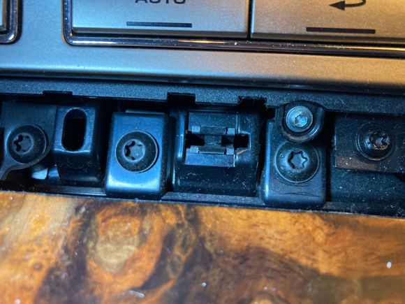 With trim removed, ashtray front attachment screws are exposed. They are the two center T30 screws. Notice one is "under" an attachment screw for the console control buttons.