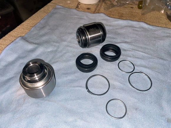 The new spherical bearings, one intact the other with the boots and clips removed. Note almost no grease in the new bearing.
