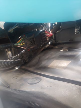 harness is located inboard of washer fluid tank