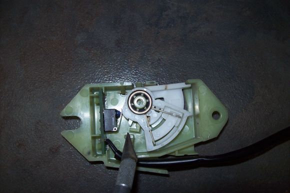 This illustrates the ratchet mechanism overextended.  No gap to the housing but most significant is the gap between the white stop tab and the notch to the right it is supposed to rest against.  Brake light stays on.