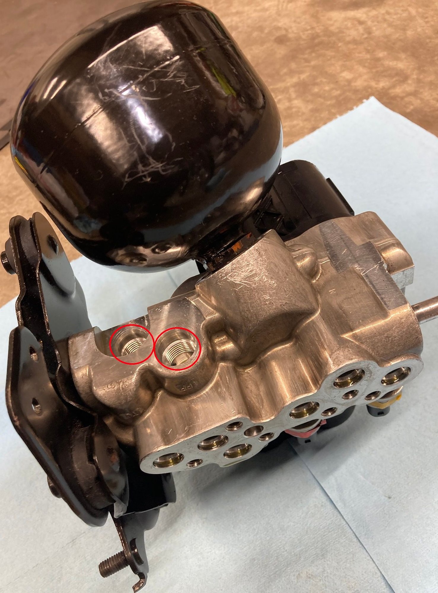 2008 SL55 AMG Front Axle Valve Unit highlighting two threaded ports where the threaded plugs are inserted.