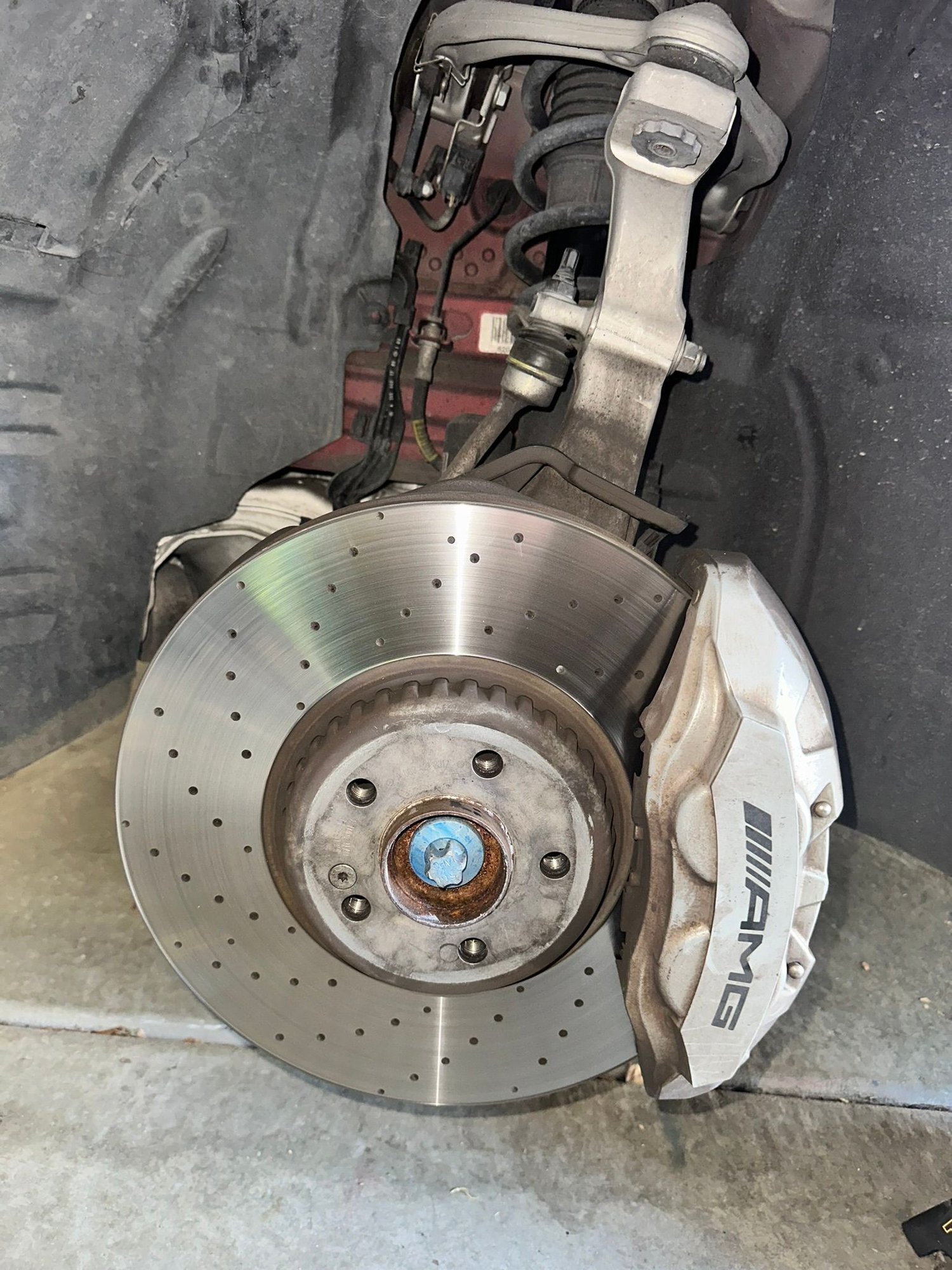 We took the wheel off the next day to have a better look (it was closing time at Discount Tyre). You can see a thin black line on the steering knuckle just where that bolt goes through.