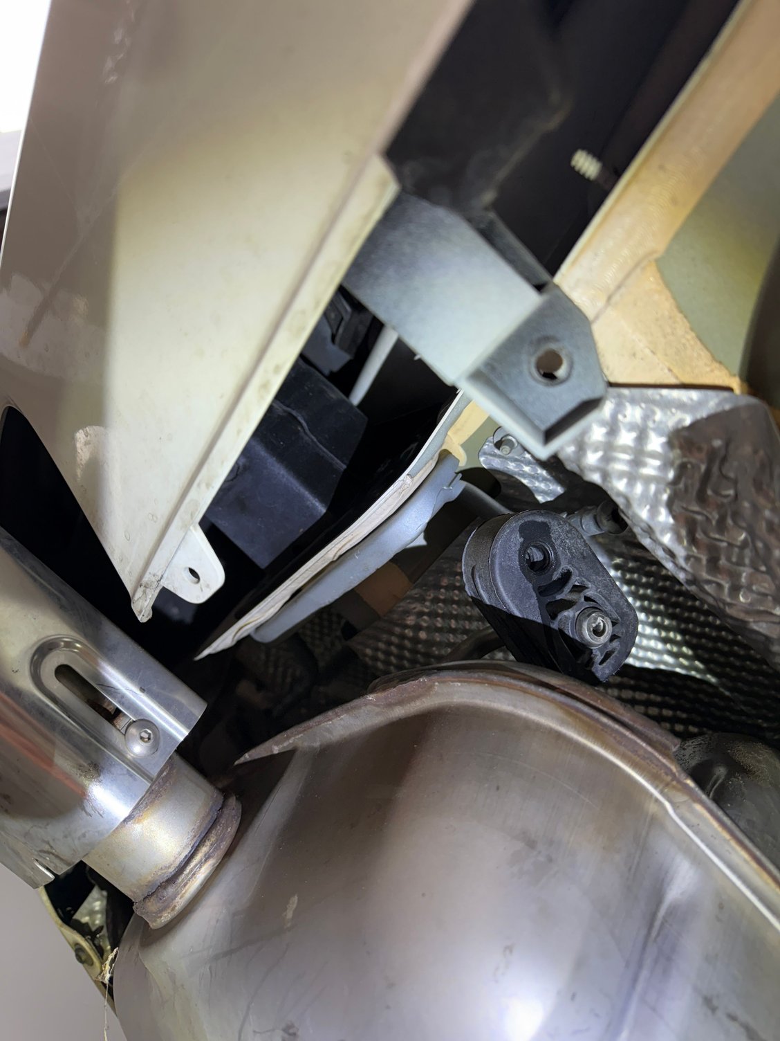 One of the 6 exhaust hanger rubber holders to be removed in order to drop the exhaust.  