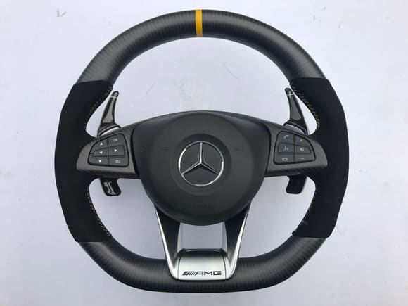 Matte carbon with matte panels with black alcantara with yellow Stitches 
Matte black Brabus Race paddles 
Yellow chapter ring
AMG lower bracket surrounding in matte carbon 
Airbag cover in black/yellow stitch