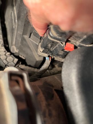 Move the large connector out of harm's way. Then completely remove the front of the battery box. Do not worry about dropping the hold down screw because it stays securely n the hole.