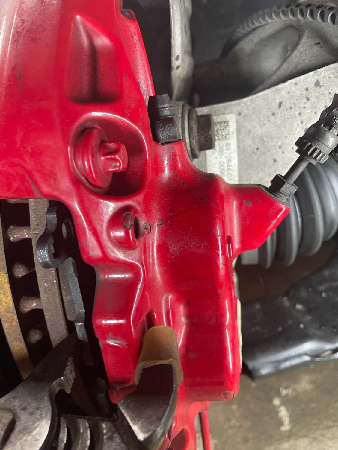 Pliers with a bit of plastic tube to keep from damaging the coating on the caliper 