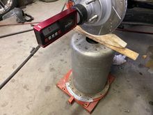 The assembly, with rotor, is more than I can deal with, with one hand. So I made a wooden cradle to put on my floor jack to hold things up, while cutting the upper mounts loose.
Notice the "turn-plate", under the set-up. This ensures the wheel is turned 15 degrees both ways for correct caster check.