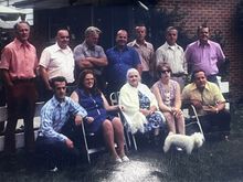 My father is wearing a gray shirt and has his arms folded.