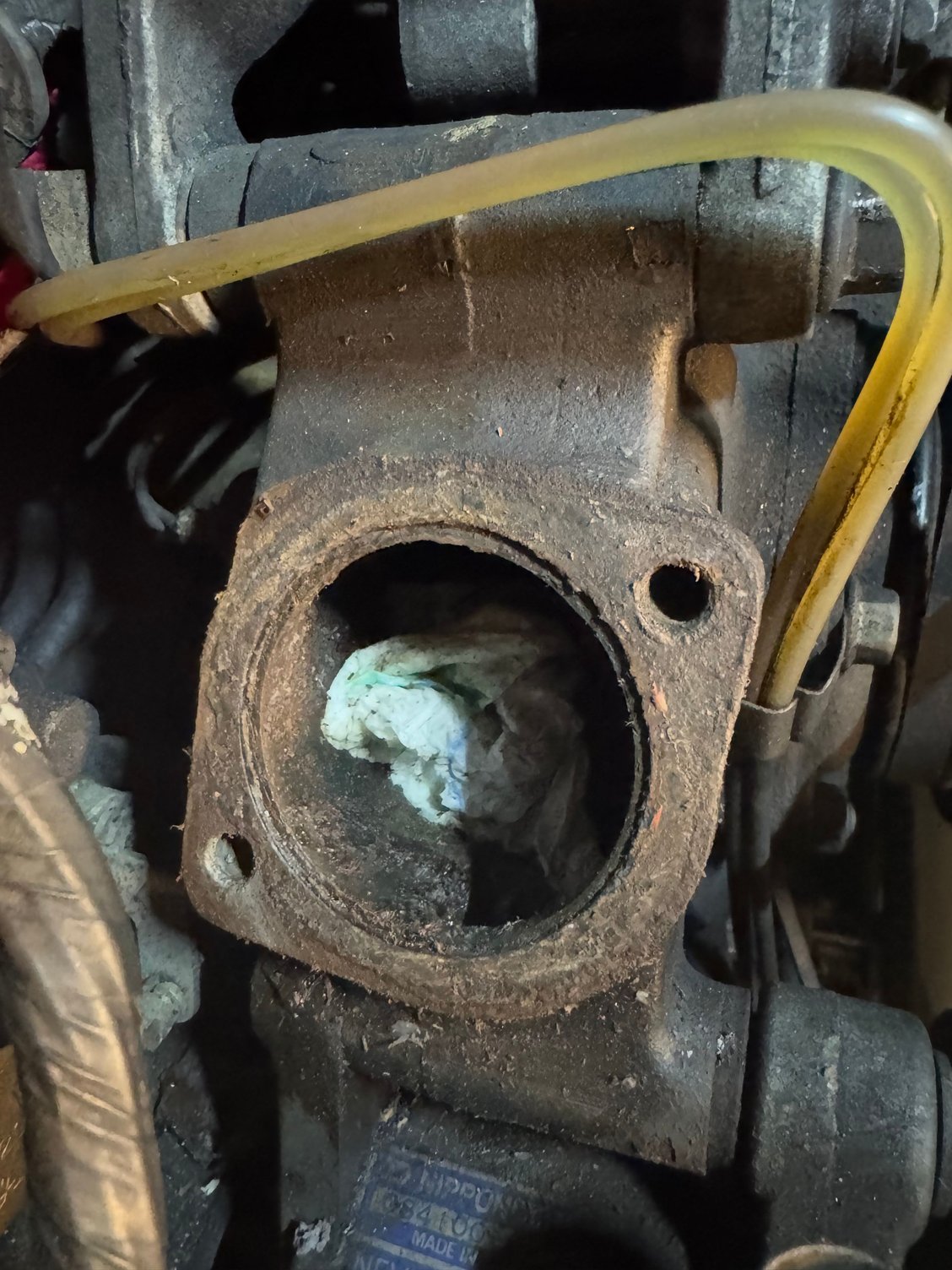 Toss your thermostat, and carefully plug the opening with a small shop towel. Grab a razor blade and some solvent/soap and get to scraping. Clean and wipe down carefully. Remove the towel and put in your new thermostat, along with the new gasket. Put back the housing neck.