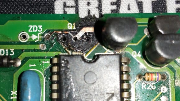 Damage to board, eyelets lifted on Q1, and broken solder runs.  A run is lifted under the IC chip that is supposed to extend to the lead (on left) of the transistor Q1.