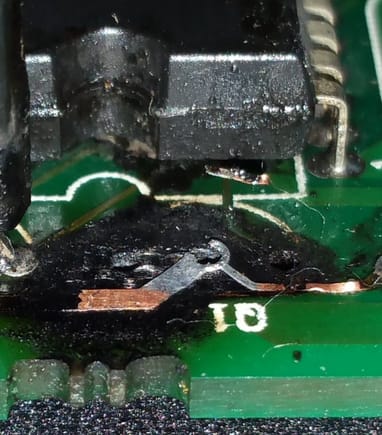 Close-up of burned up solder runs. Note the trace that runs from underneath the IC chip to the right lead of Q1 is nearly gone.